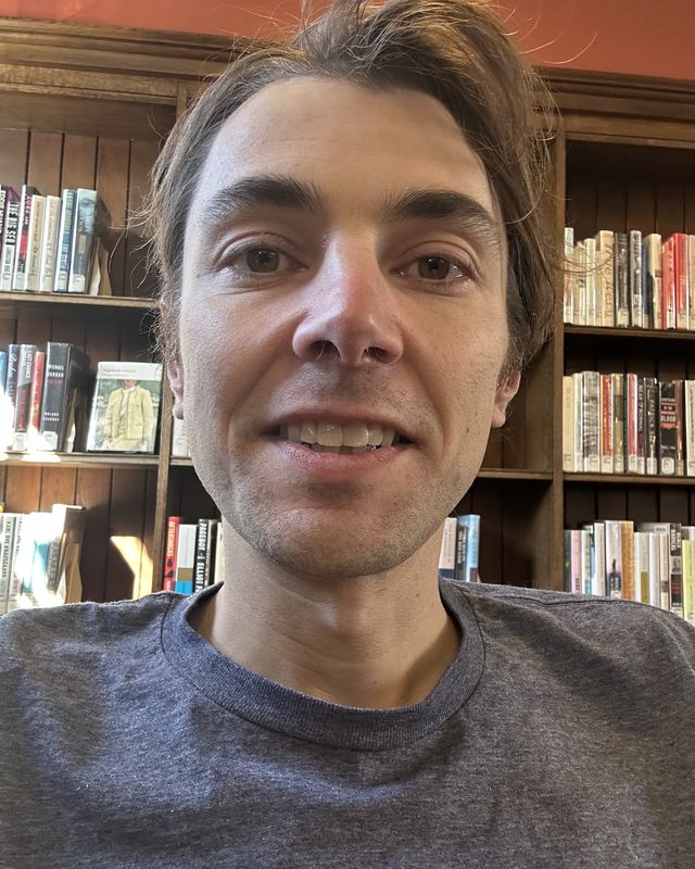 Owen Poindexter in front of library bookshelves